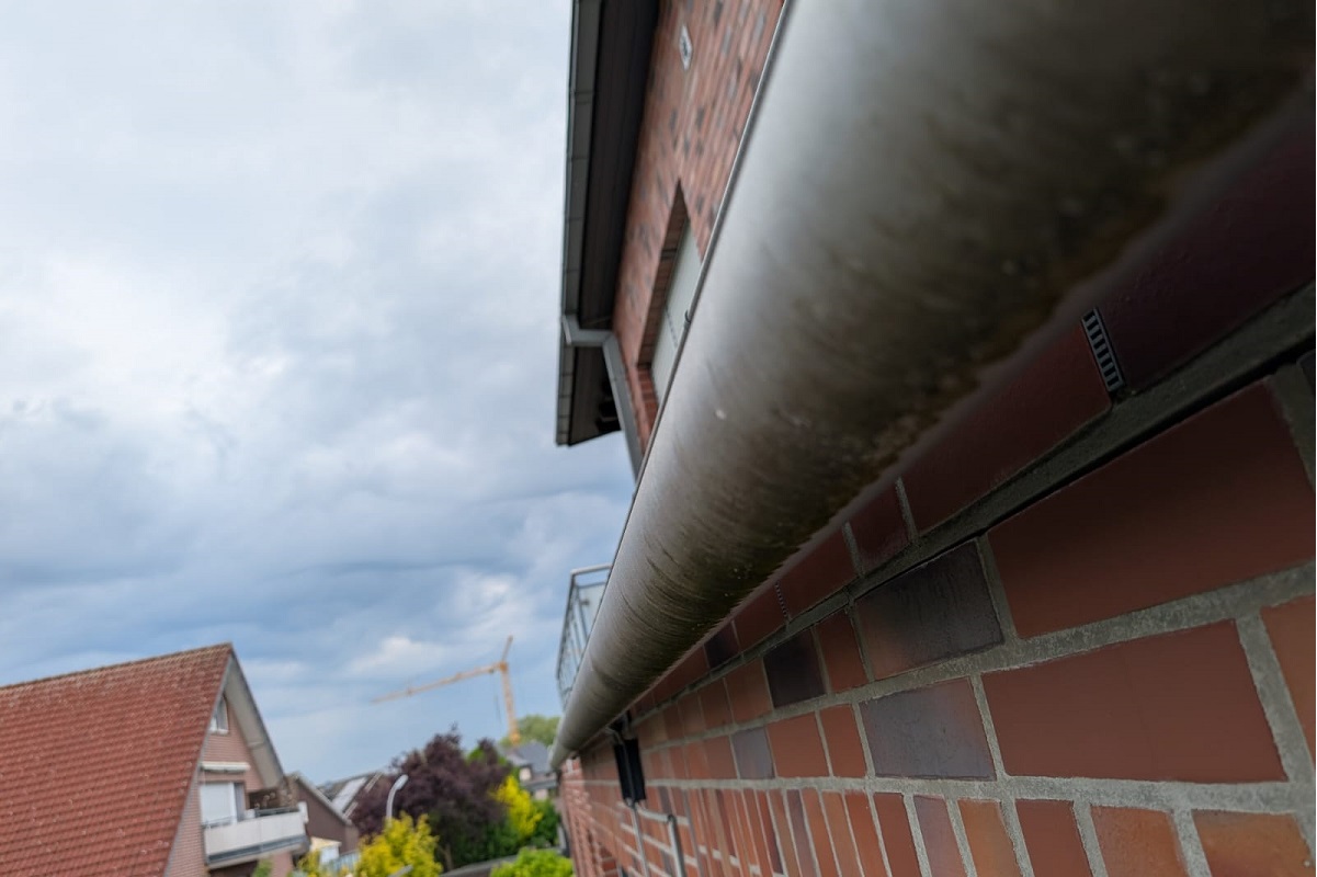 Professionelle Dachrinnenreinigung an einer Gewerbehalle in Borken mit Hebebühne